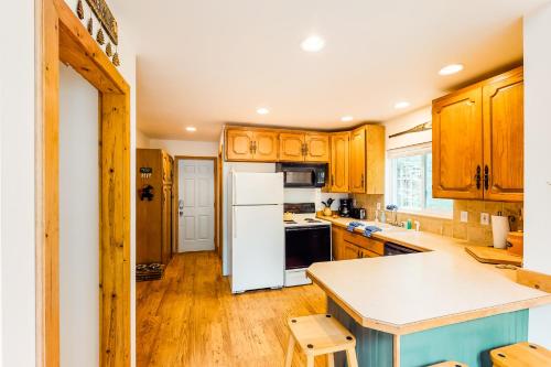 a kitchen with wooden cabinets and a white refrigerator at Alpine Home in Lilliwaup