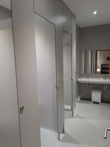 ein Badezimmer mit zwei Glastüren und einem Waschbecken in der Unterkunft Hosteria de Gonzar in Gonzar
