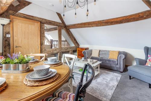 a living room with a table and a couch at Guest Homes - The Merchant House Apartments in Hereford