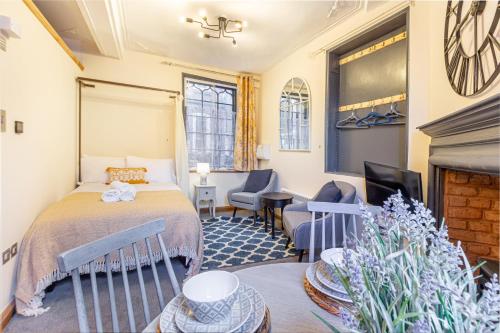 a hotel room with a bed and a fireplace at Guest Homes - The Merchant House Apartments in Hereford