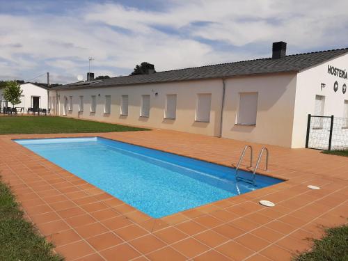 a swimming pool in front of a building at Hosteria de Gonzar in Gonzar