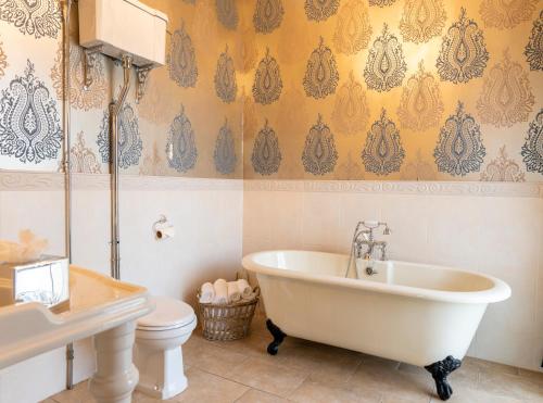 a bathroom with a white tub and a toilet at Ringwood Hall Hotel & Spa in Chesterfield