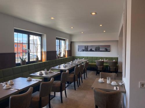 a dining room with tables and chairs and a large window at Hotel B4 in Limburg an der Lahn