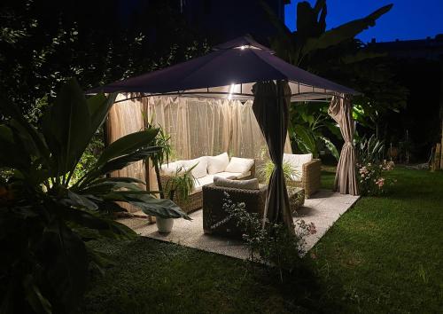 a gazebo with a couch in a yard at Palazzo Cini Luxury Rooms in Pisa in Pisa