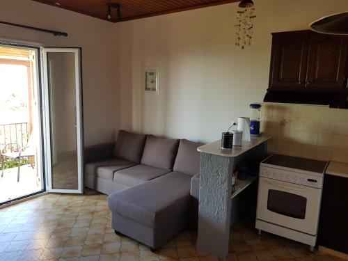 een woonkamer met een bank en een keuken bij Filippos Apartments "Apartment 2" in Spartia