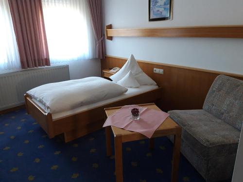 a hotel room with a bed and a chair at Bengel's Hotel zur Krone in Mülheim-Kärlich
