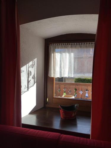 a window in a room with a red curtain at Lo PONTON in Introd
