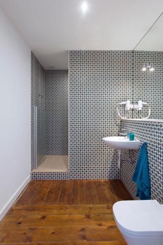a bathroom with a toilet and a sink and a shower at Lost Lisbon :: Chiado House in Lisbon