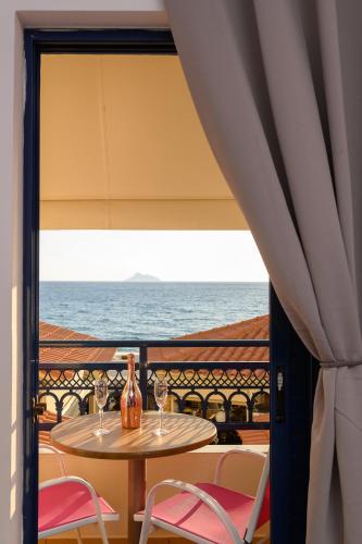 a table and chairs with a view of the ocean at Studios Paradise in Kalamaki Heraklion