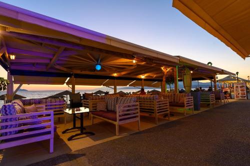 a restaurant with tables and chairs under a large umbrella at Studios Paradise in Kalamaki Heraklion