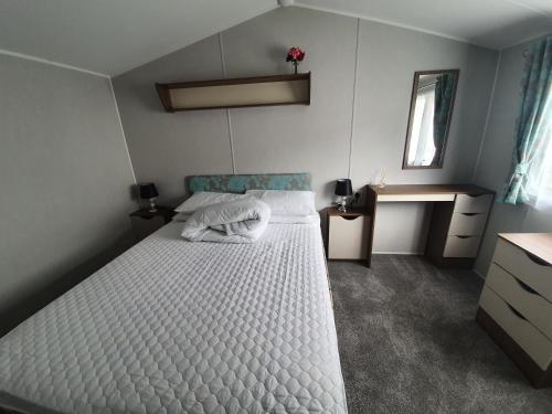 - une chambre avec un lit blanc et un bureau dans l'établissement Haven Rockley Park, Lytchett Bay View, Private Holiday Home, à Lytchett Minster