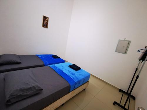 a bed in a white room with a camera at SinggahSini Homestay Balok / Gebeng in Kuantan