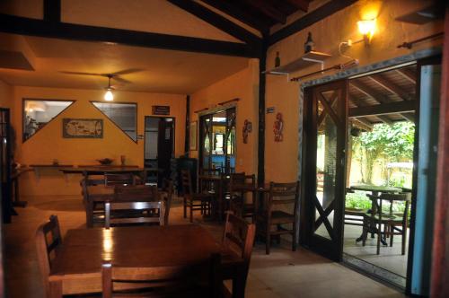 咎凱的住宿－Pousada Baobá，用餐室配有木桌和椅子