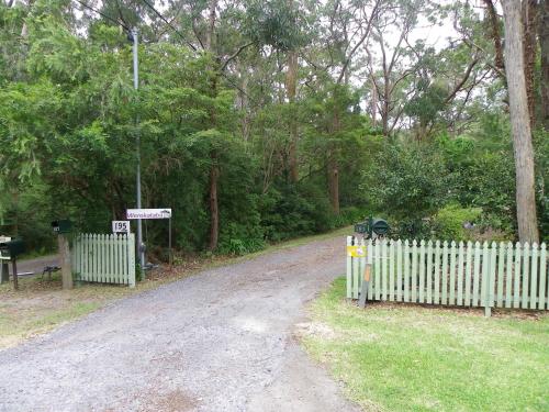 a dirt road with a white fence and trees at Werekataba in Mount Hutton