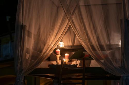a room with a table with two candles and curtains at Tra gli Alberi e il Mare in Sirolo