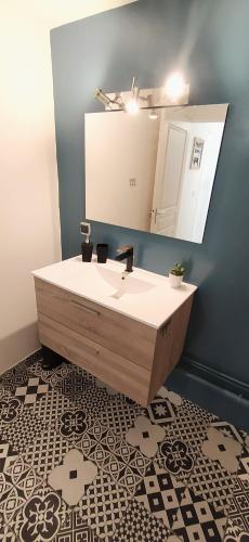 a bathroom with a sink and a mirror at Le Clipper in Saint-Pierre