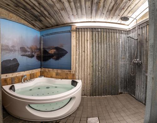 a bathroom with a tub and a shower at Villa Kultaa in Kotka