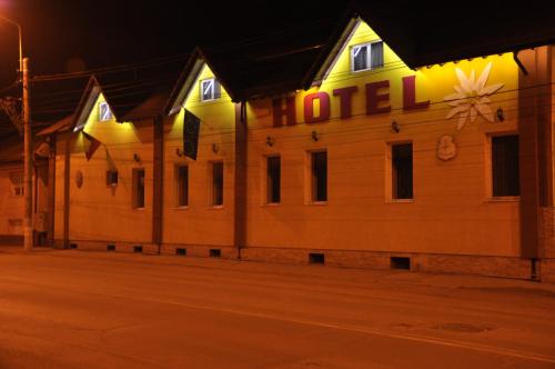 a building with a hotel sign on it at night at Hotel Edelweiss in Mediaş