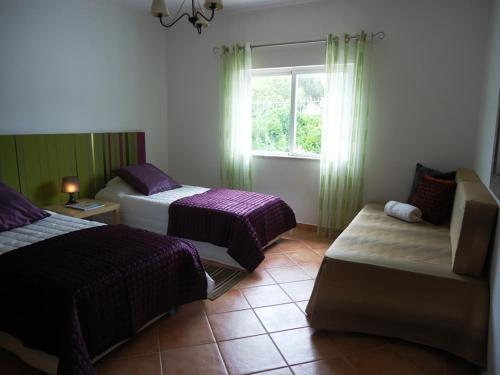 a hotel room with two beds and a window at Villa Olive in Loulé