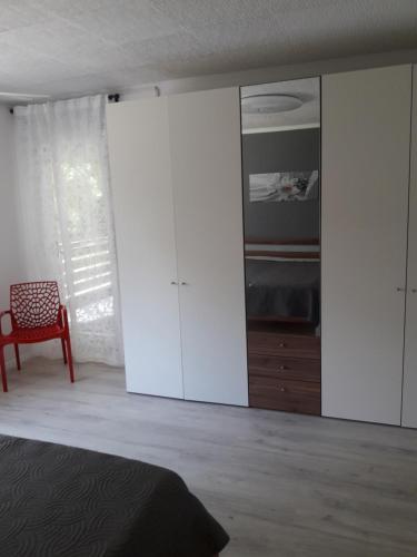 um quarto com armários brancos, uma cama e uma cadeira em Ferienwohnung an der Klinge em Aalen
