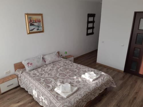 a small bedroom with a bed with a blanket at Pensiunea agroturistica Casa Sirca in Boghiş