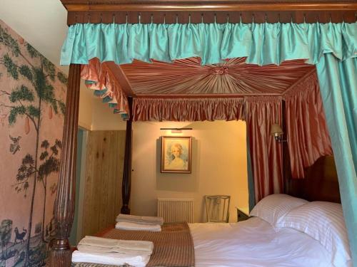 a bedroom with a canopy bed in a room at Barns Library in Peebles