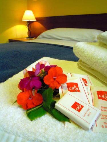 a bouquet of flowers and a book on a bed at Loremar in Gaeta