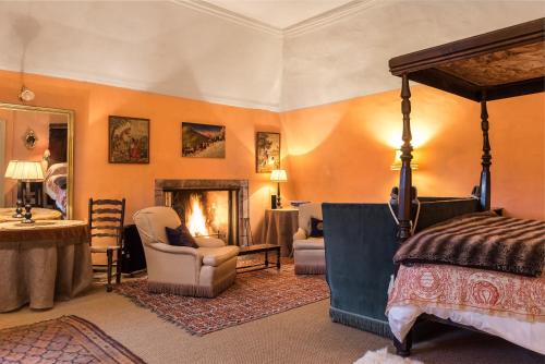 a bedroom with a bed and a chair and a fireplace at Queen Mary's Chamber in Peebles