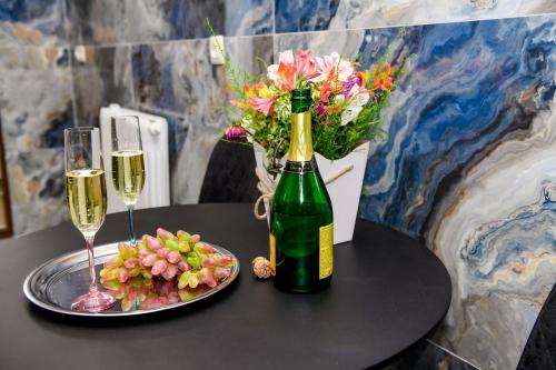 a table with a bottle of champagne and a plate of flowers at Hotel Late in Mtskheta