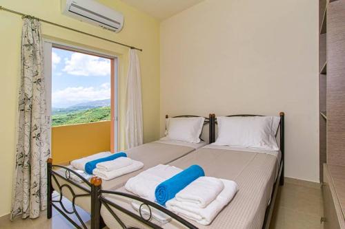 ein Schlafzimmer mit einem Bett mit zwei Kissen und einem Fenster in der Unterkunft Mantarini House in Áyios Andónios