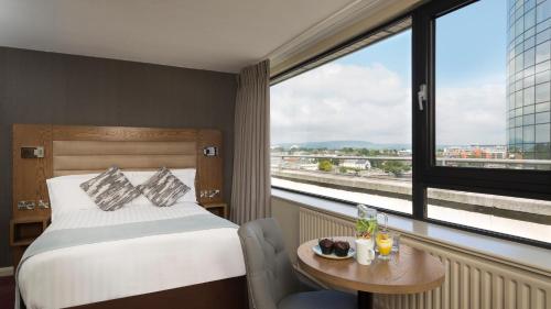 a hotel room with a bed and a table and a window at Limerick City Hotel in Limerick