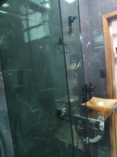 a glass shower in a bathroom with a glass wall at Santa Cecília Pousada in Guarujá