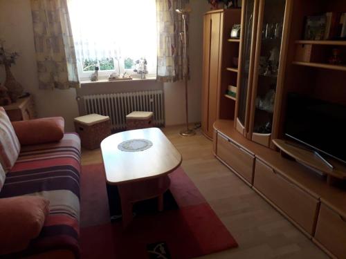 a living room with a couch and a coffee table at Ferienwohnung Dreiländereck in Haidmühle