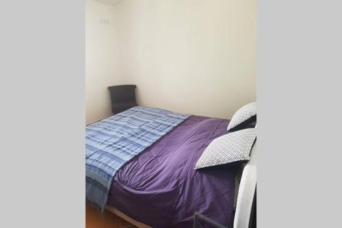 a bedroom with a bed with a purple comforter at appartement tra mare e monti in Ghisonaccia