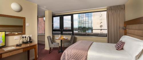 a hotel room with a bed and a desk and a window at Limerick City Hotel in Limerick