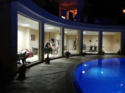 a man standing next to a swimming pool in a building at Wonderful family villa with sea view in Byala