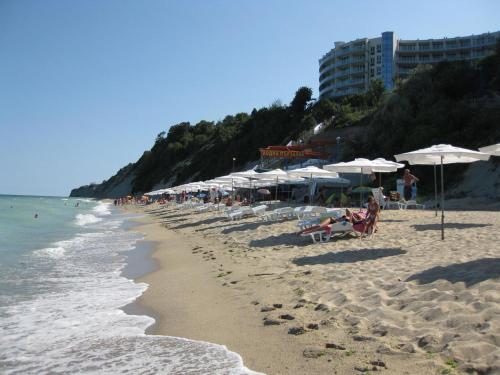 a beach with umbrellas and people sitting on the sand at Wonderful family villa with sea view in Byala