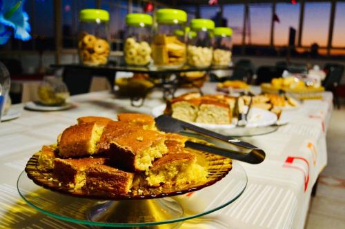 - une table avec une assiette de gâteau et d'autres desserts dans l'établissement Hotel Dias - By UP Hotel, à Pouso Alegre
