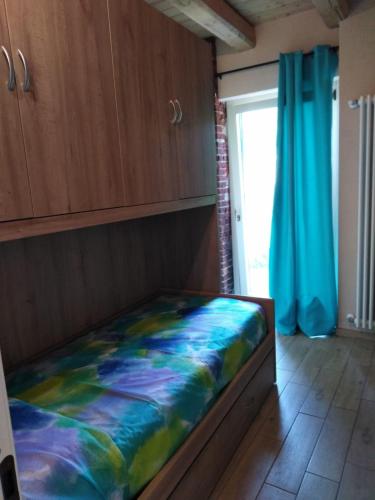 a bed in a room with a blue curtain at LA LEGIUN STRANIERA in Boves