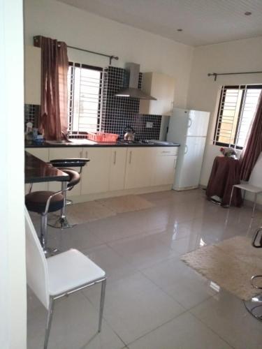 a large kitchen with a table and a refrigerator at Portersville Private Lodge in Freetown