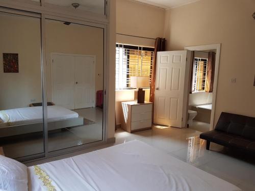 a bedroom with a mirror and a bed and a couch at Portersville Private Lodge in Freetown