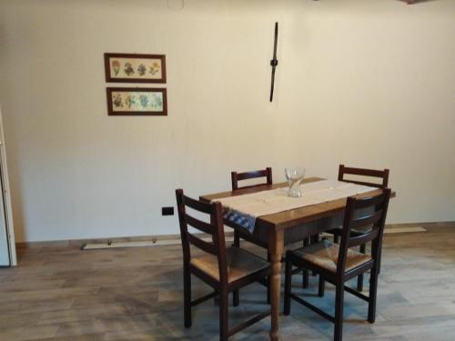 a wooden table with chairs and a wine glass on it at LA LEGIUN STRANIERA in Boves