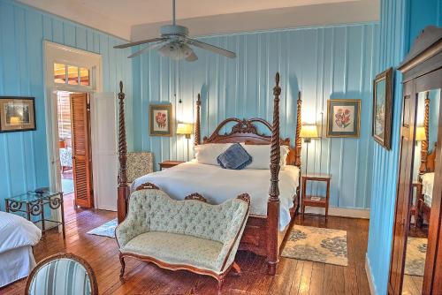 a bedroom with a bed and a chair and blue walls at Open Gates Bed & Breakfast in Darien