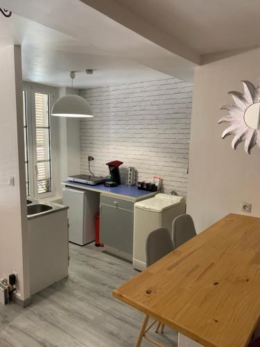 une cuisine avec une table et un comptoir dans l'établissement Appartement complet, hyper centre d’Auxerre., à Auxerre