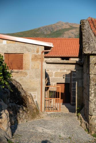 a stone house with a staircase leading to a doorway at Casa do Morgado in Mondim de Basto