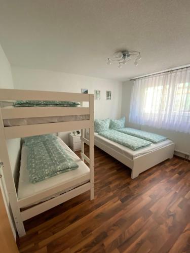 two bunk beds in a room with wooden floors at Ferienwohnung Müller in Lahr