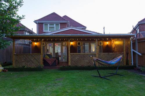 a house with a porch with a chair in the yard at Langley Guest House Nr Pinewood Studios in Slough