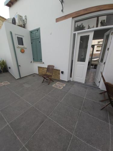 a patio with two chairs and a door at Magdalene's City House Inn in Larnaka
