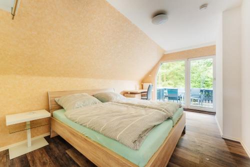 a bedroom with a bed and a large window at Ferienwohnungen Hafermarkt in Wildemann