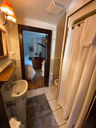 a bathroom with a shower and a sink and a toilet at The Olde Angel Inn in Niagara on the Lake